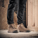 Person wearing brown Scruffs work boots and black pants in a construction setting